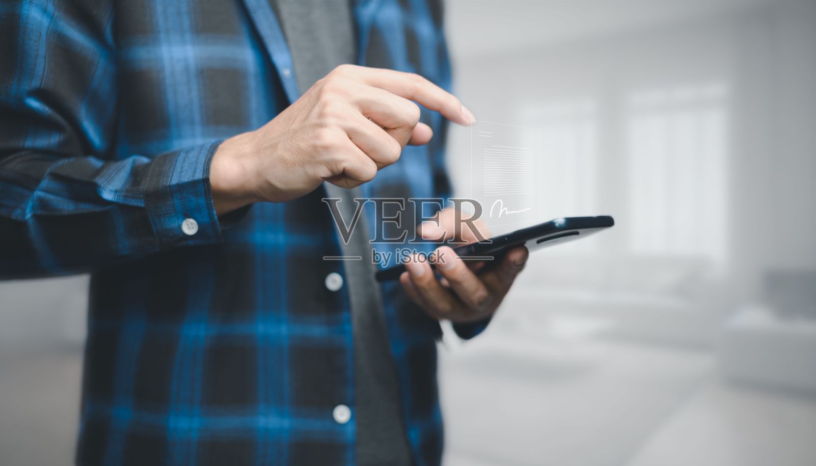 一个人拿着一部手机,上面漂浮着一个签名的文件图标,这就是数字文档的概念照片摄影图片