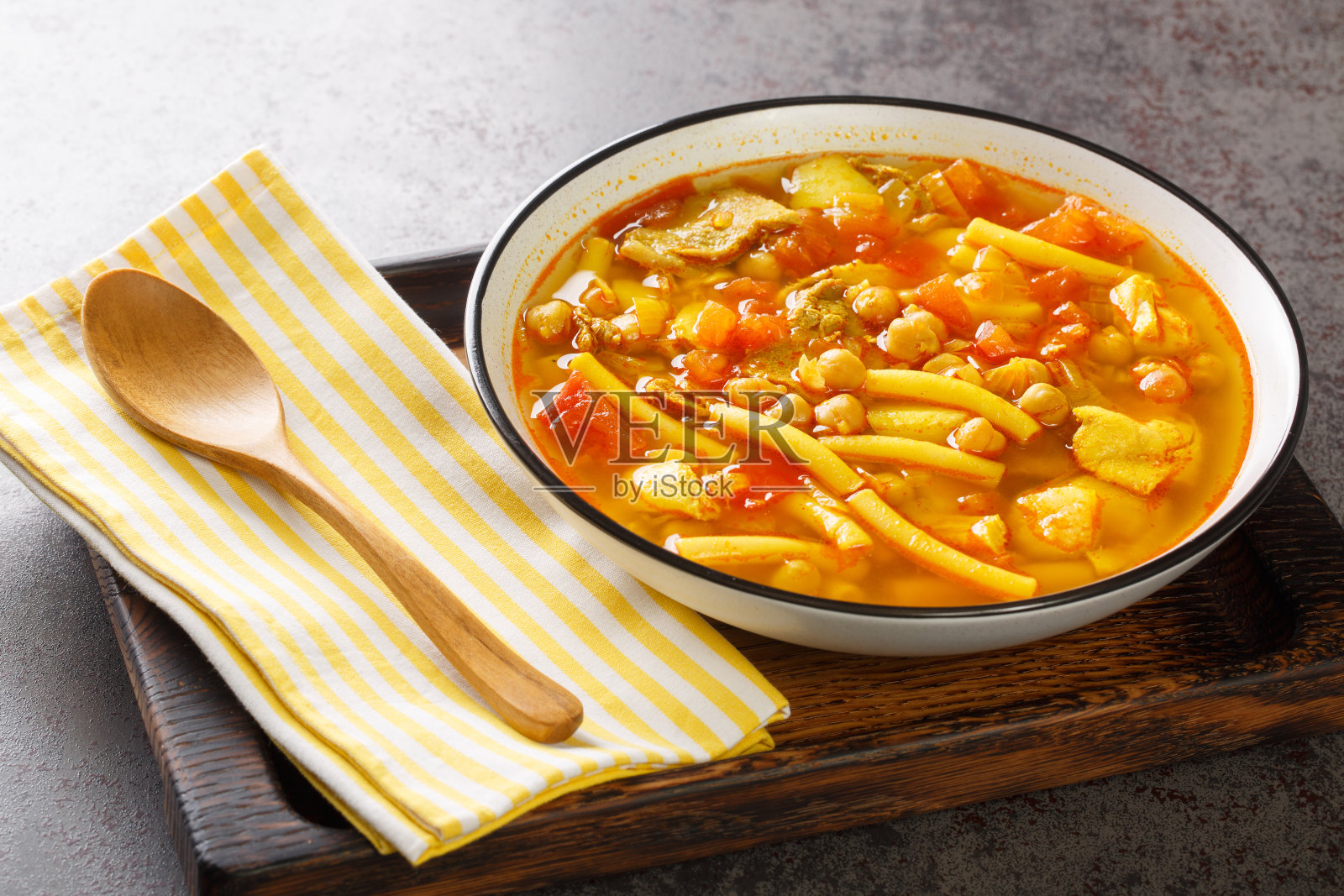 加那利汤,肉,意大利面,鹰嘴豆和蔬菜特写在盘子里。水平照片摄影图片