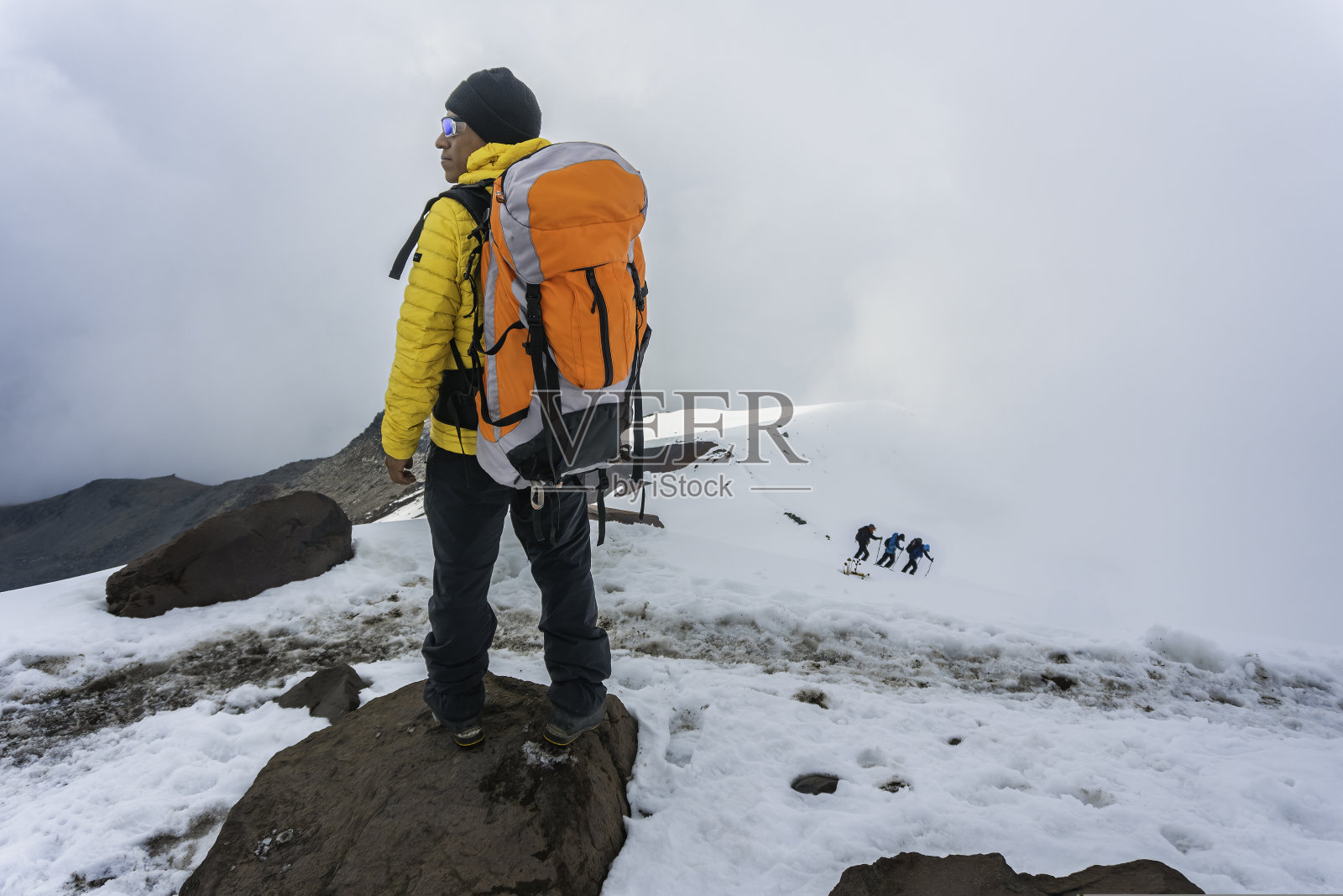 背着背包的男人在山上徒步旅行。照片摄影图片