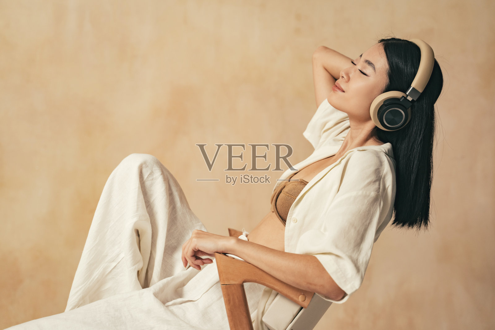 亚洲女性在紧张的一天工作后休息,戴着耳机听着平静的冥想音乐照片摄影图片