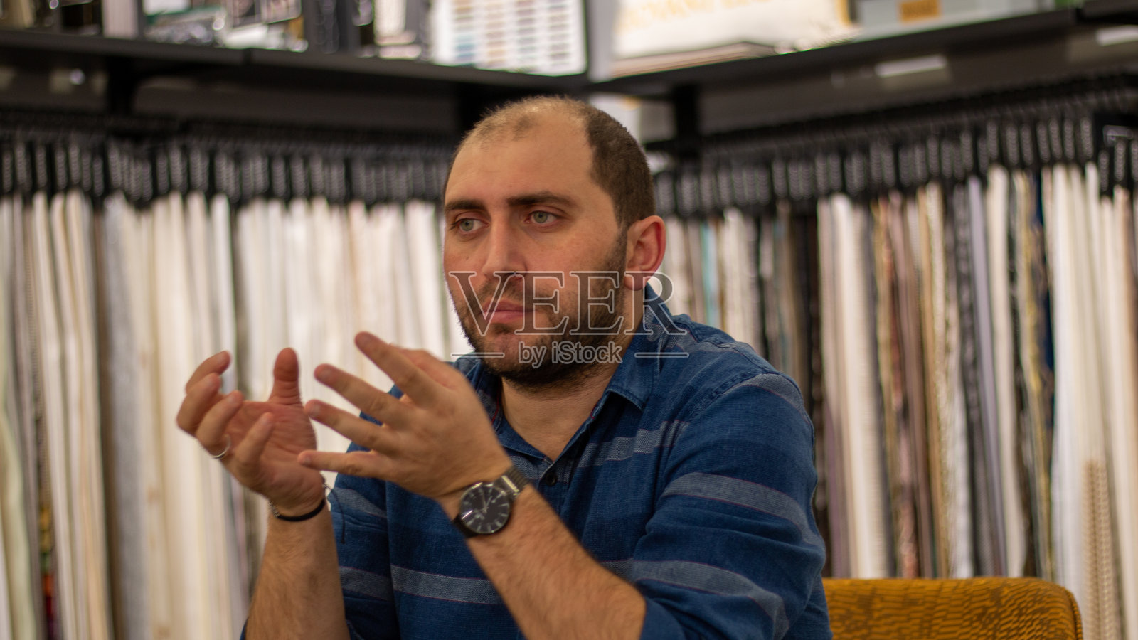 坐在桌旁的蓝眼睛留着胡子的年轻人告诉我照片摄影图片