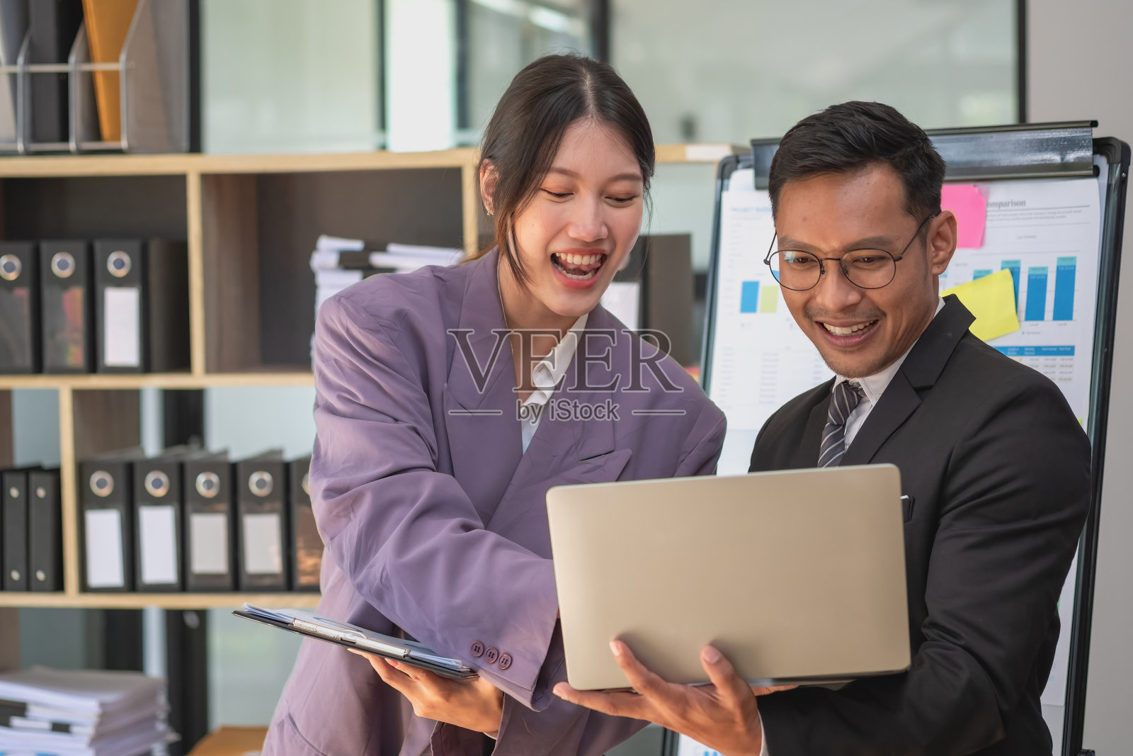 营销、财务、会计、计划两名男女营销人员使用公司文件和笔记本电脑记录数据,分析公司利润。照片摄影图片