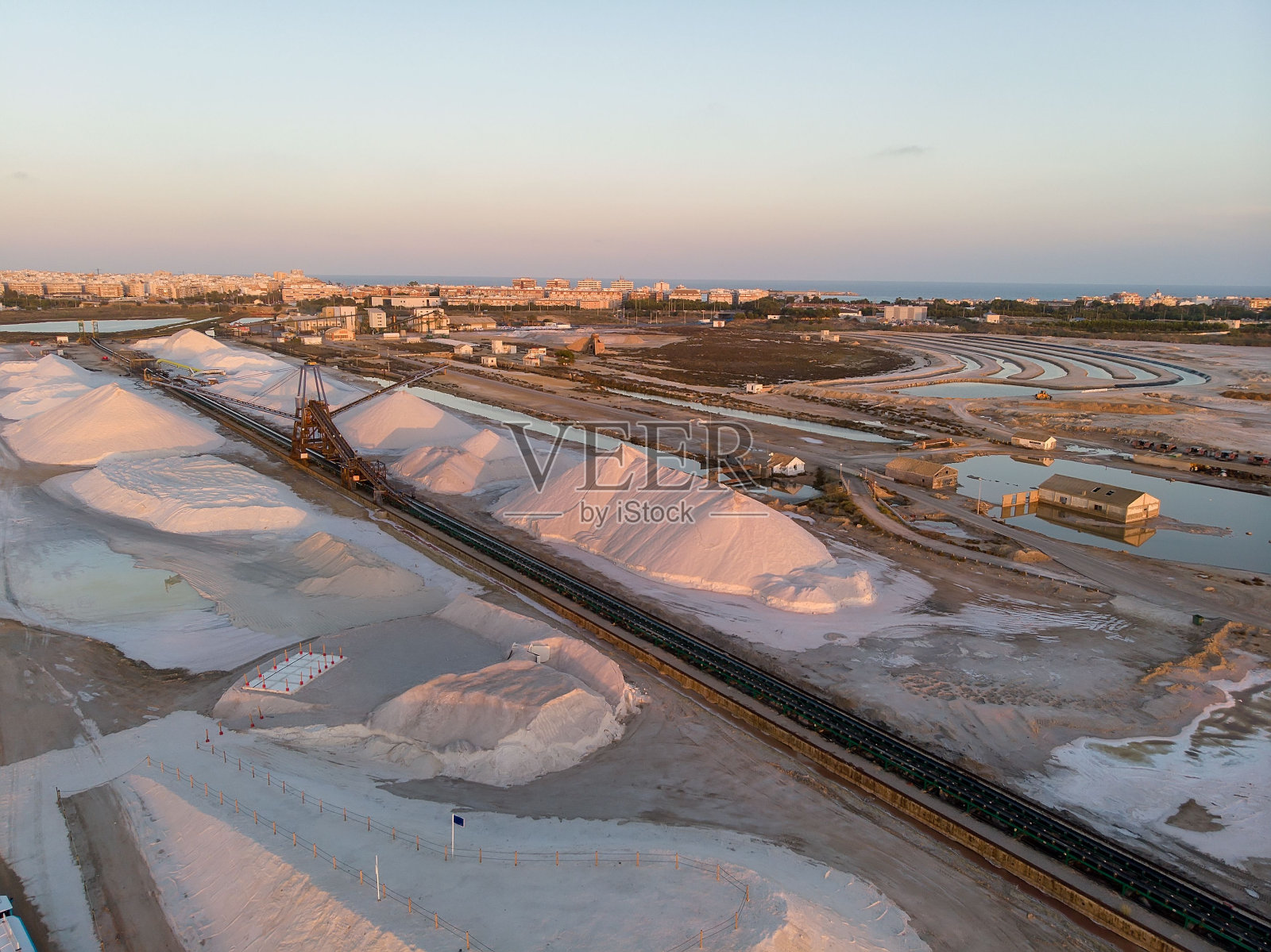 落日时分,西班牙托雷维耶哈的拉斯萨利纳斯盐厂的盐堆鸟瞰图照片摄影图片