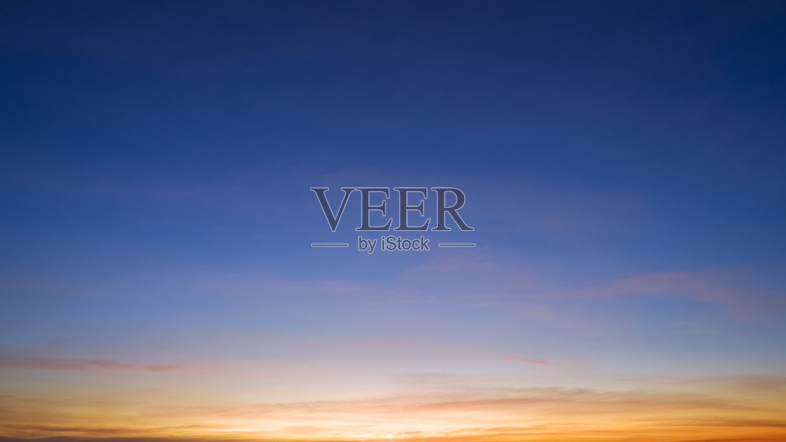 黄昏的天空背景与美丽的阳光和日落后的云在蓝色的黄昏天空照片摄影图片