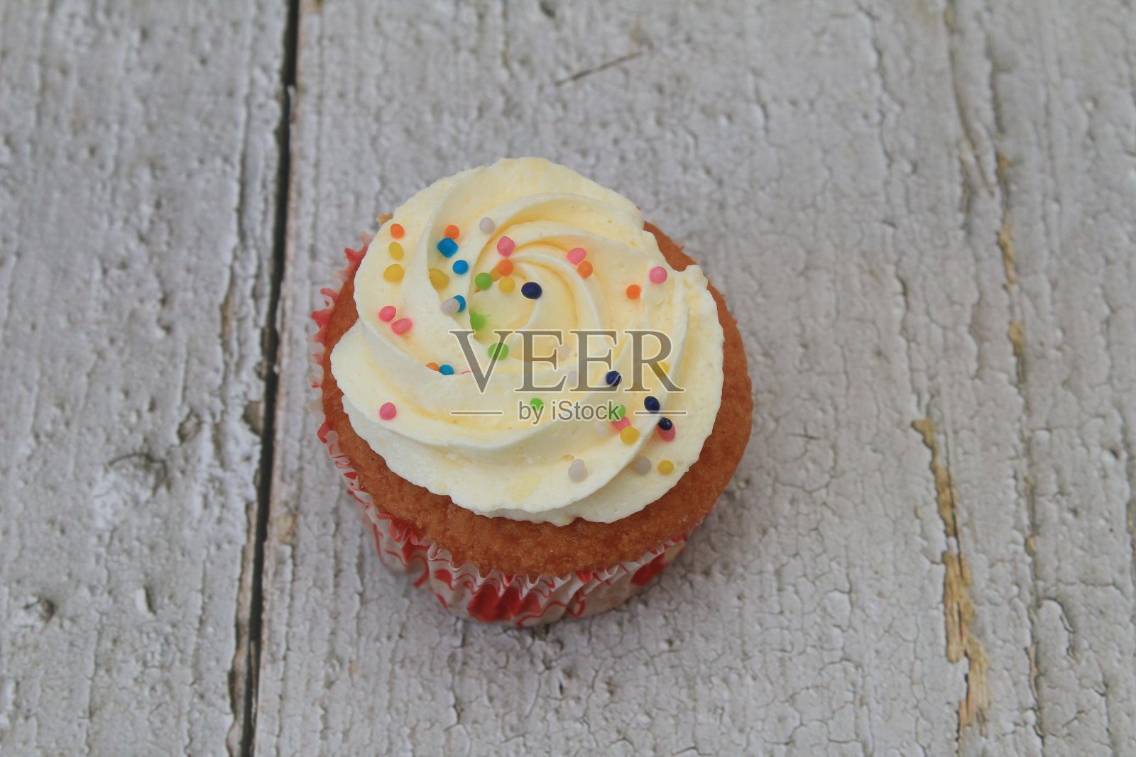 甜蛋糕与tutti frutti洒在木制桌子上白色的背景。照片摄影图片