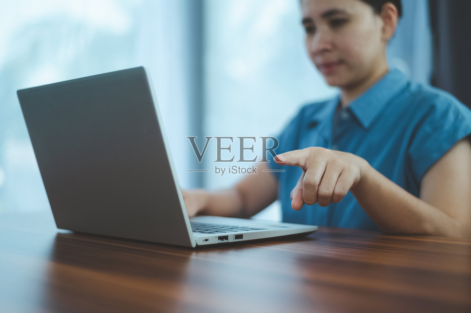 人们使用电脑的侧面视图,男性的手在笔记本电脑键盘上打字照片摄影图片