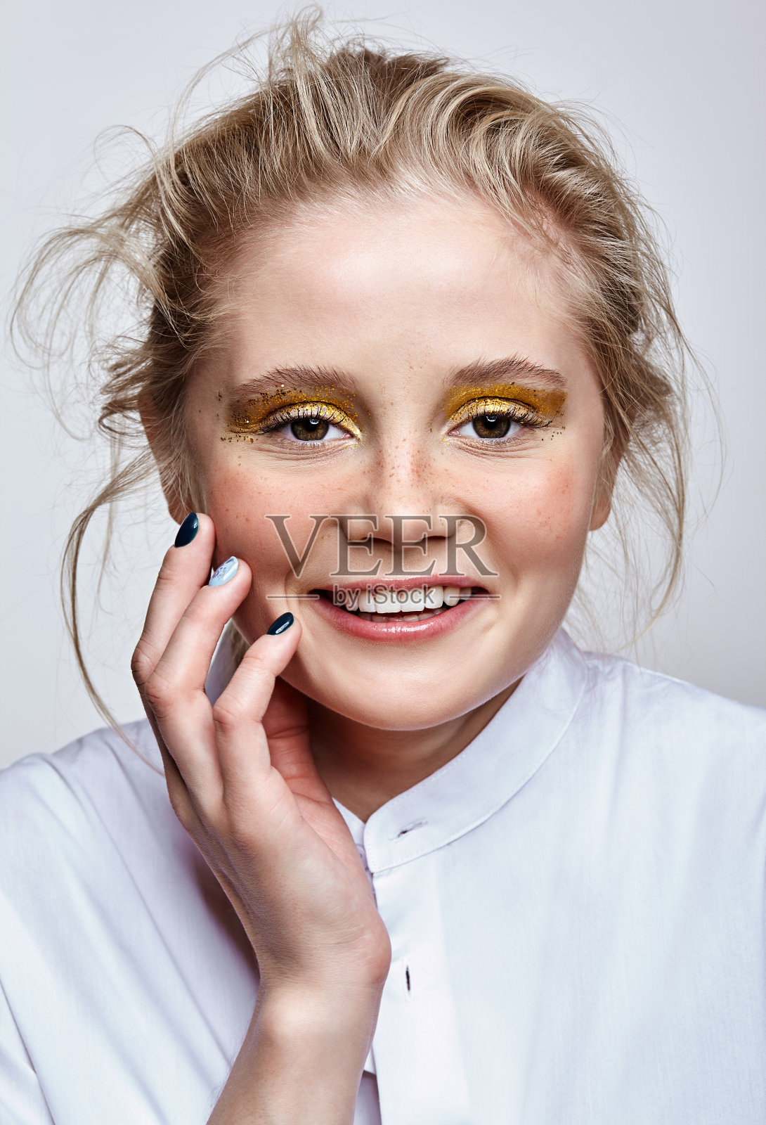 微笑女性的脸用不寻常的闪闪发光的时尚脸美妆。照片摄影图片