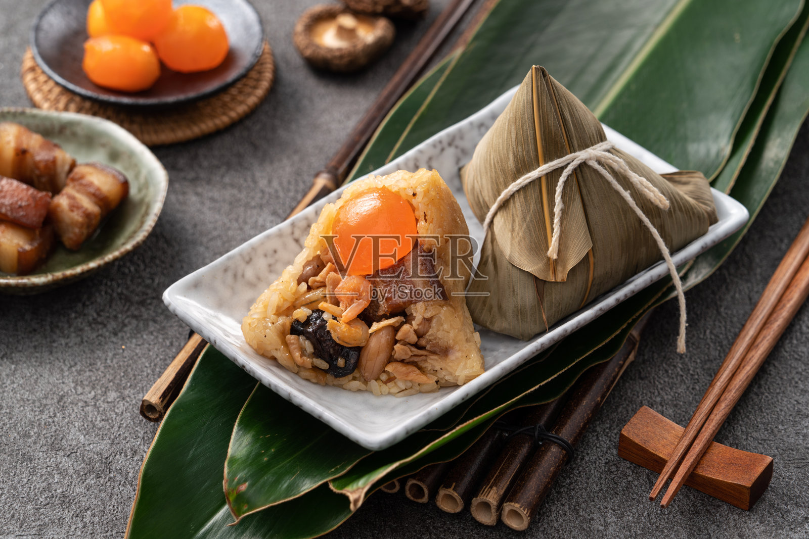 粽子,端午节的粽子,以深灰色的餐桌为背景,辅以食材。照片摄影图片