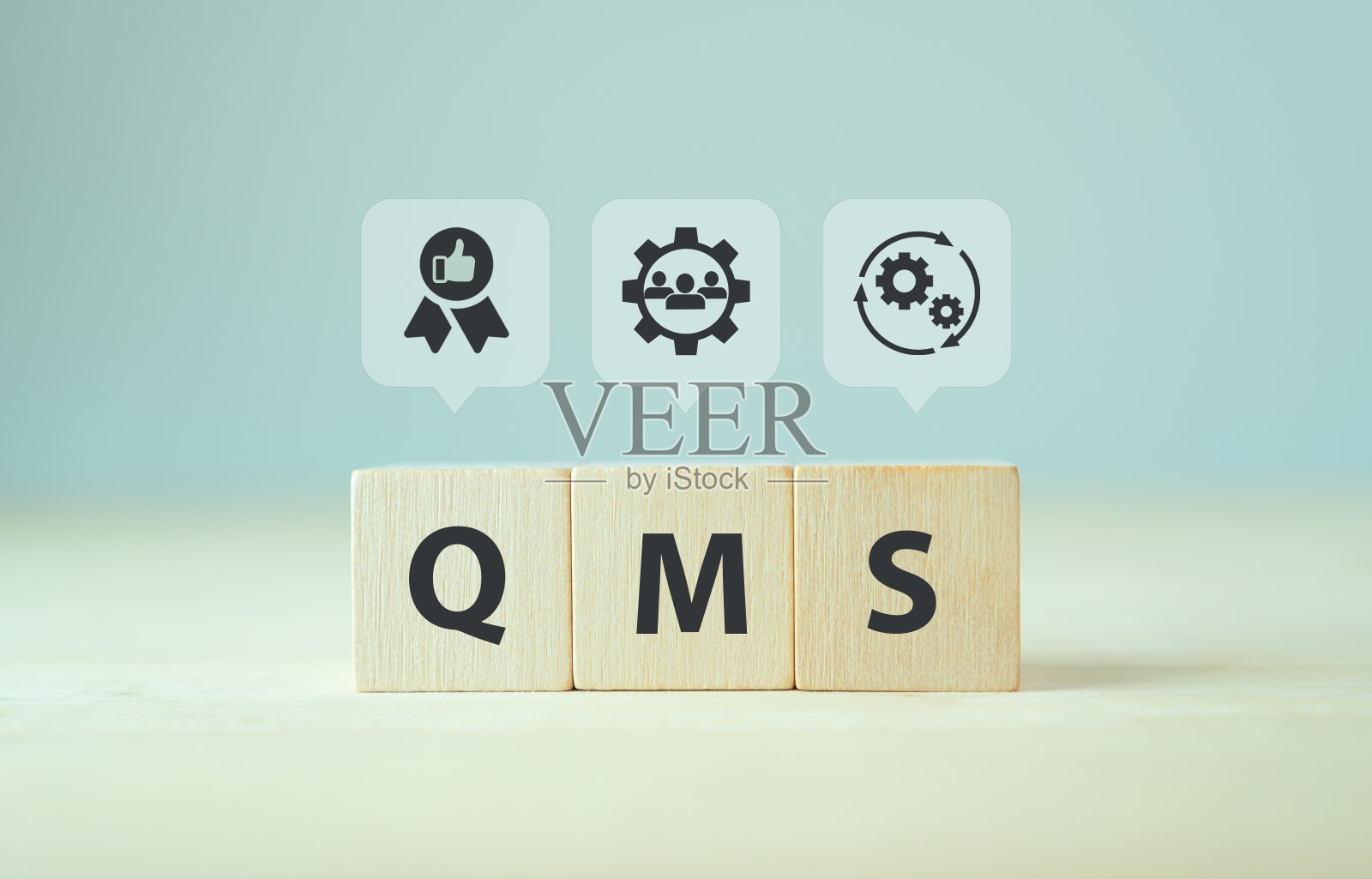 QMS,质量管理体系概念。实现质量方针和目标的正式系统。ISO 9001标准。木制立方体与缩写的QMS和符号对智能背景。照片摄影图片