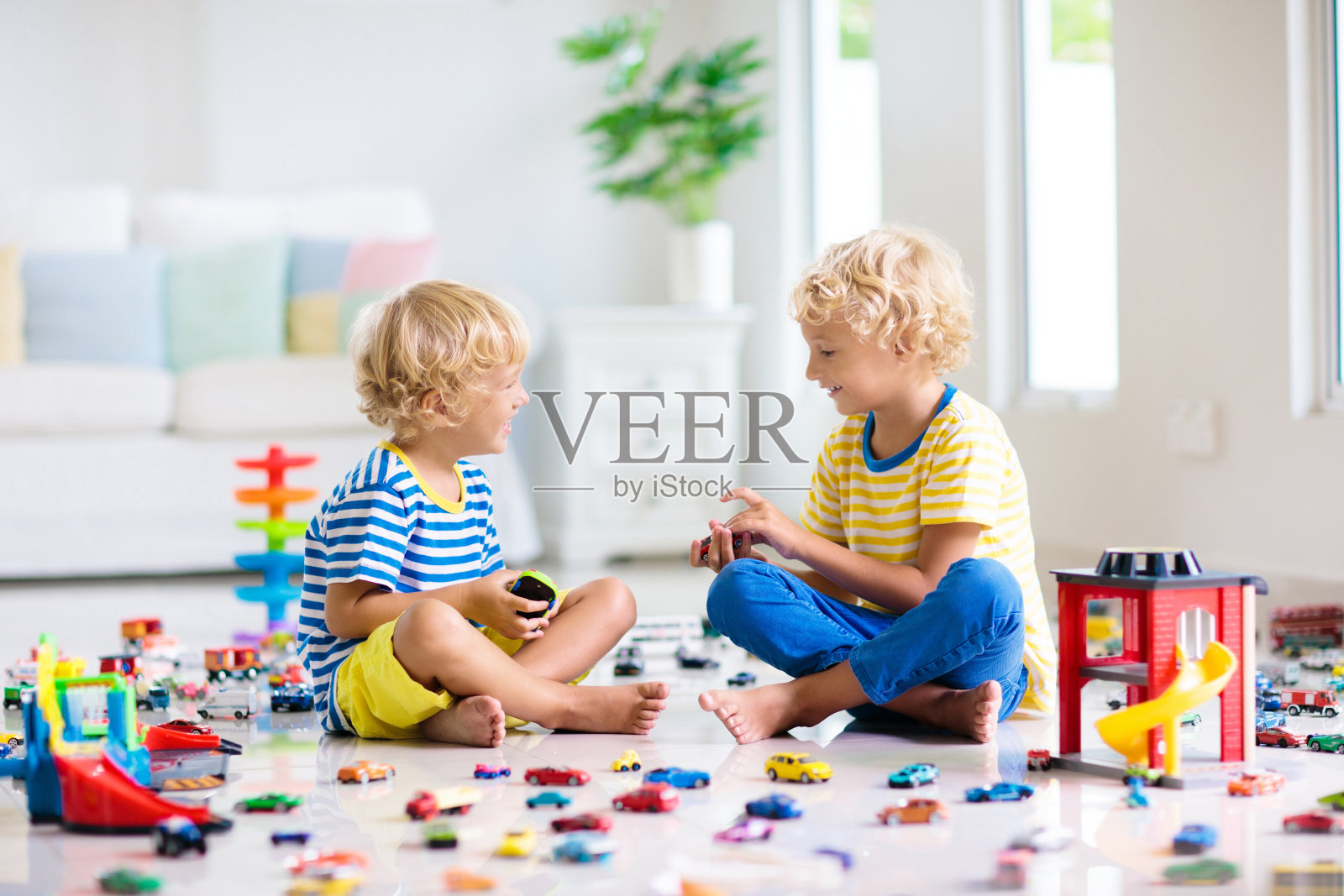 孩子们玩玩具汽车。孩子们在玩汽车玩具照片摄影图片