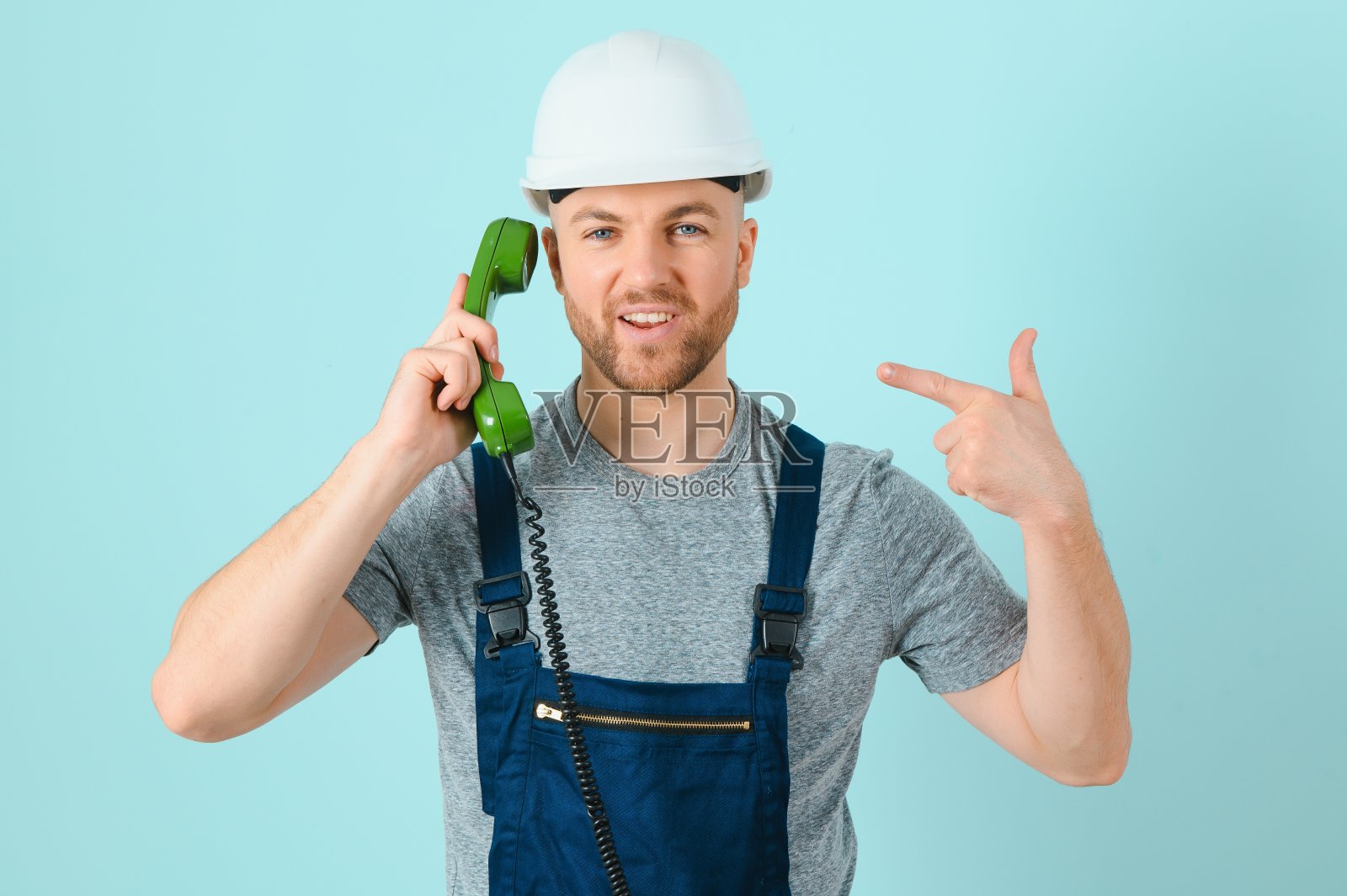请打这个号码,我帮你。工匠或电工与手机隔离背景照片摄影图片