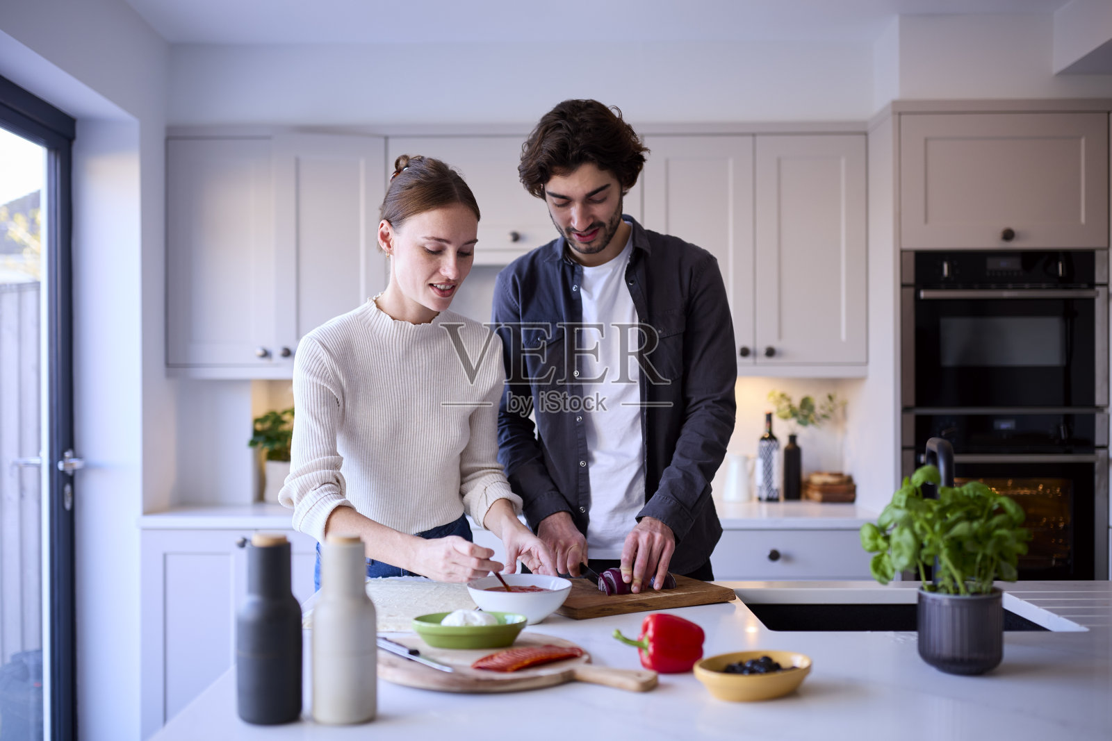 情侣在家中厨房一起制作自制披萨照片摄影图片