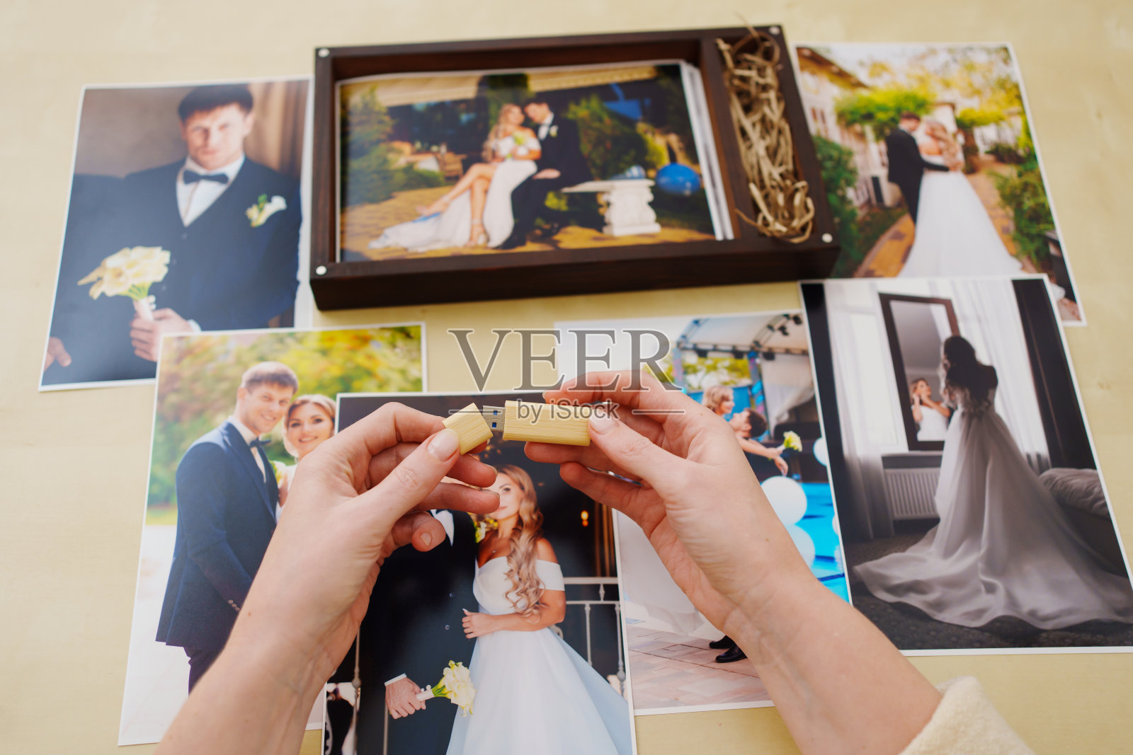 打印的婚纱照,一个木盒子和手上的优盘照片摄影图片