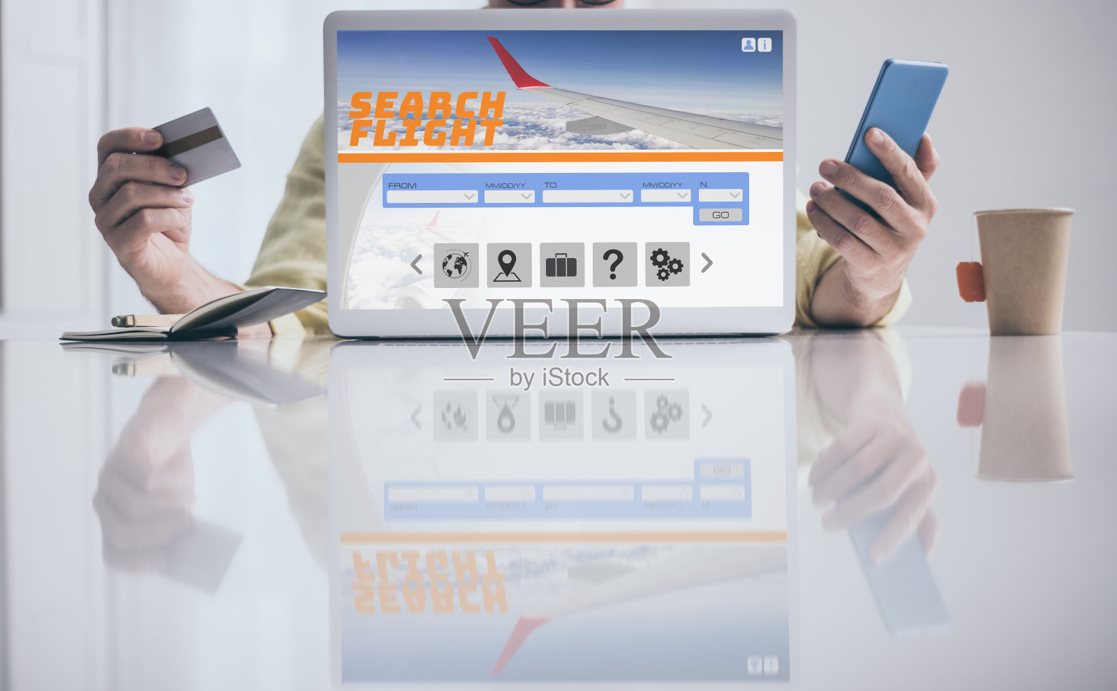 男人搜索和支付机票在笔记本电脑和手机度假。预订航班。计划旅行,预订假期照片摄影图片