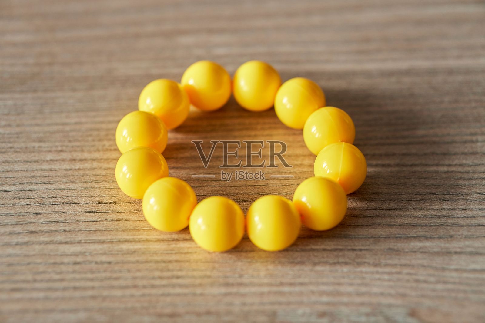 木桌上的黄球手镯的特写镜头照片摄影图片