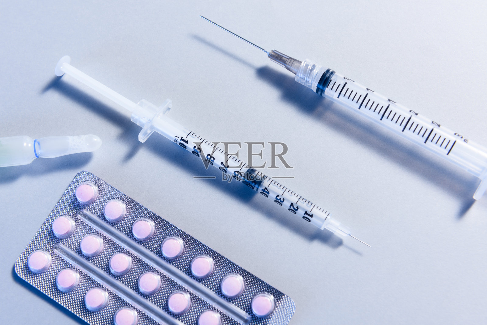 俯视图细节集与两个注射器,一个安瓿和一个水泡包,在蓝色照明照片摄影图片