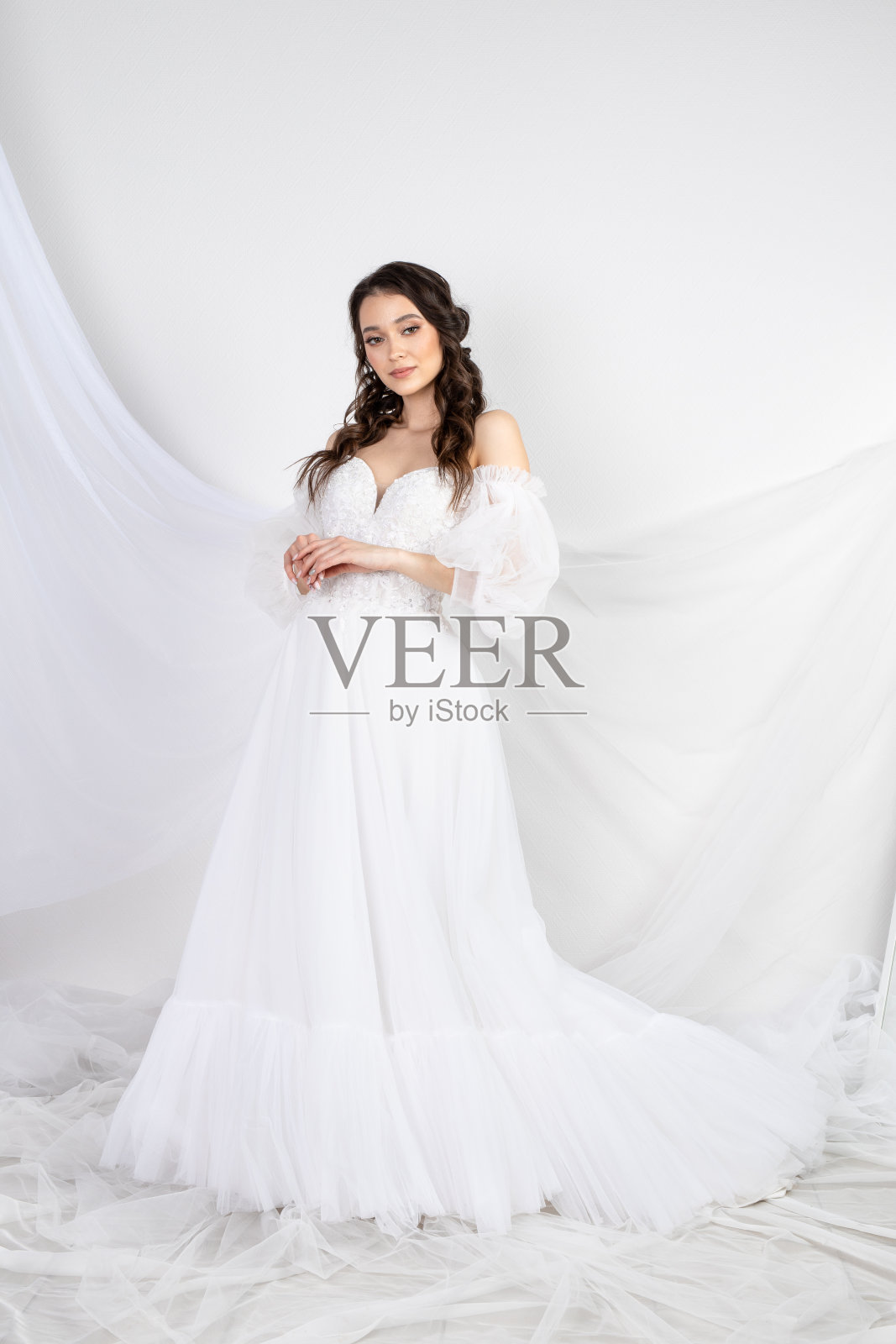 美丽性感的女人黑发在时尚长裙派对婚礼。新娘自然模型与自然化妆风格为名人白色背景照片摄影图片