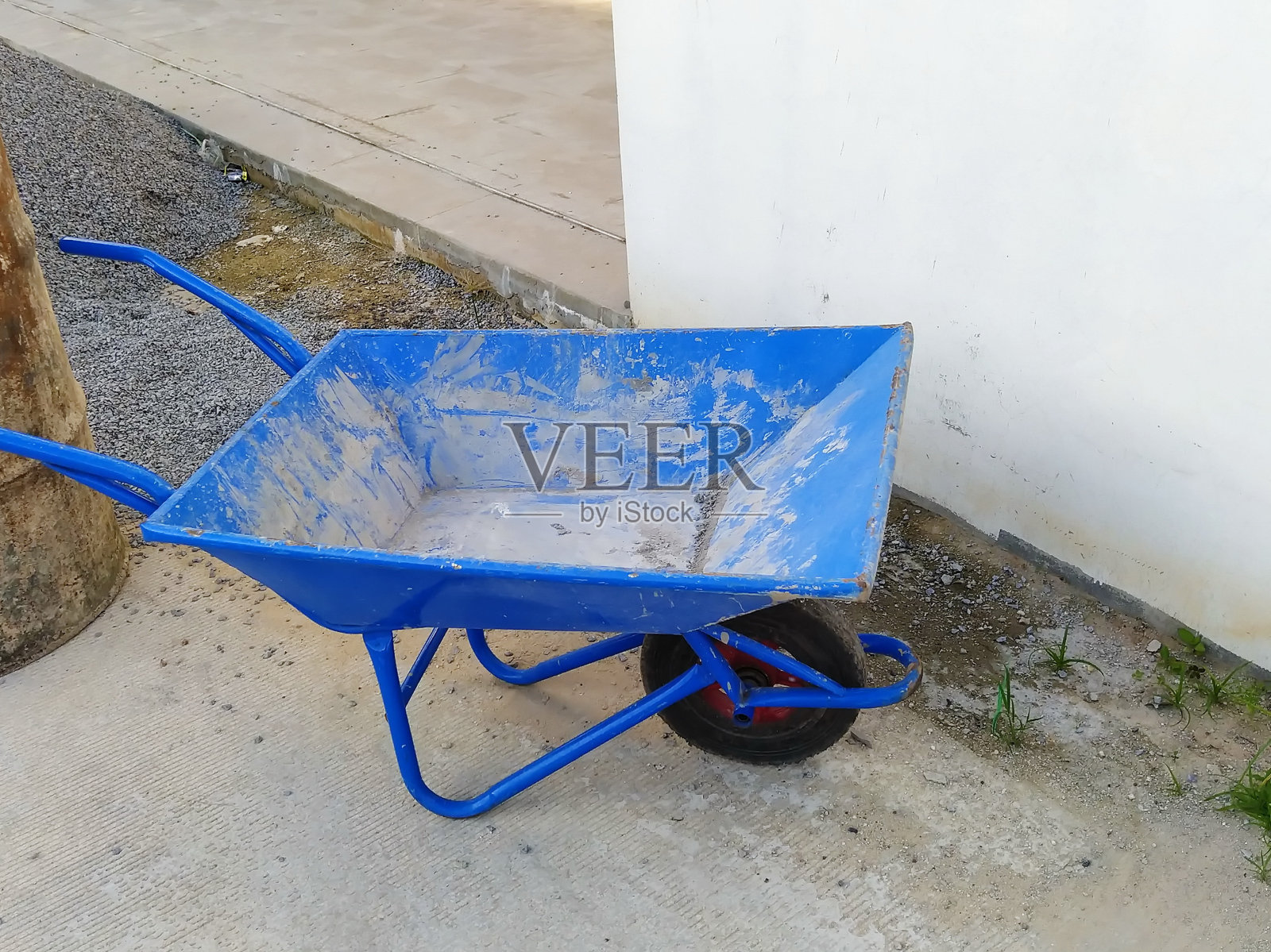 蓝色的手推车。建筑设备。旧的油箱。照片摄影图片