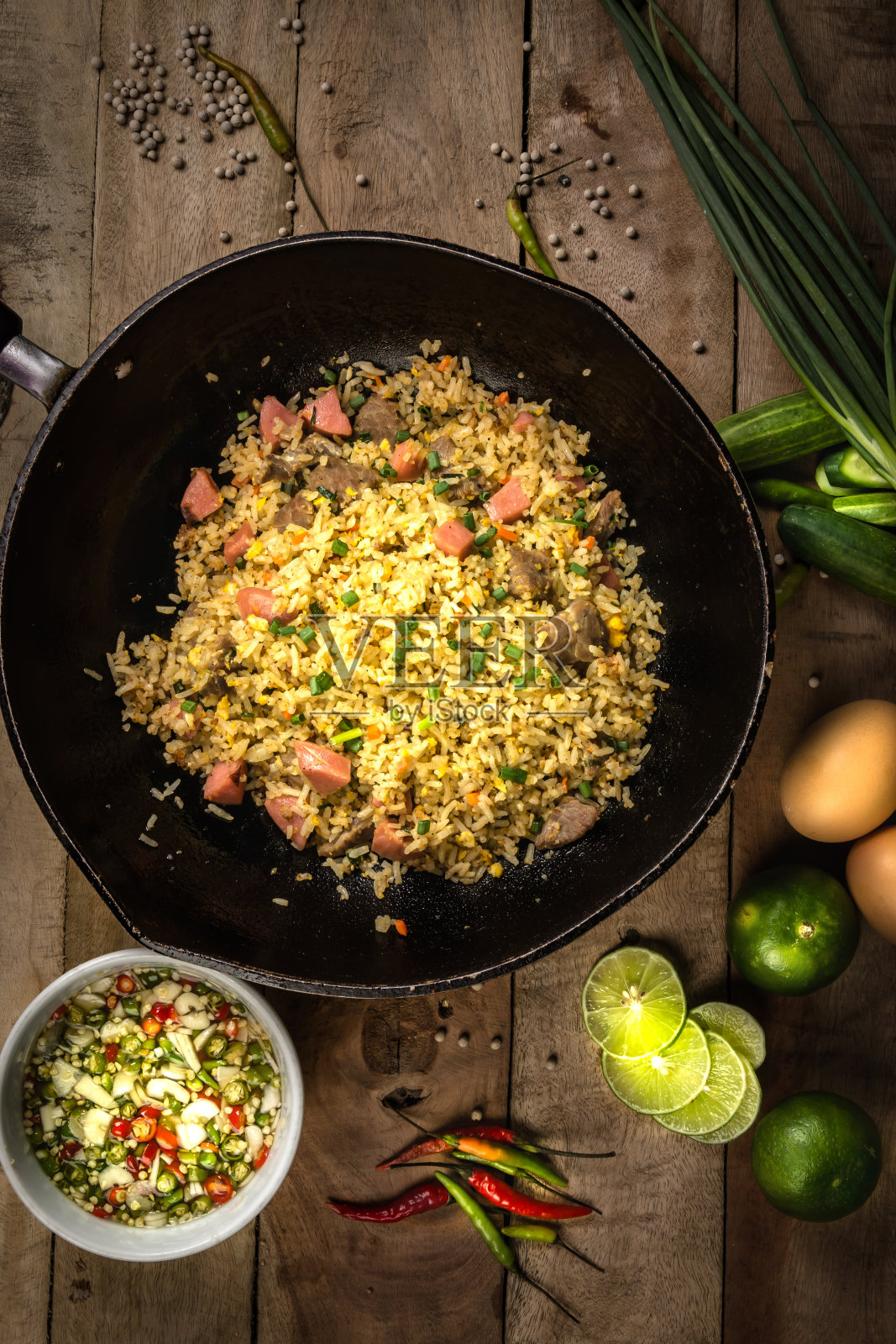 用筷子夹在盘子里的蔬菜、肉和煎蛋炒饭照片摄影图片