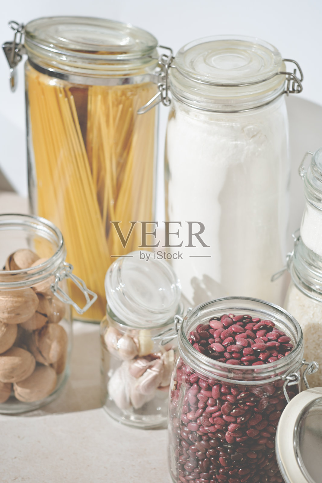 意大利面,小麦粉,玻璃罐里的豆子和坚果,厨房用品,生态储存。垂直的商店照片摄影图片