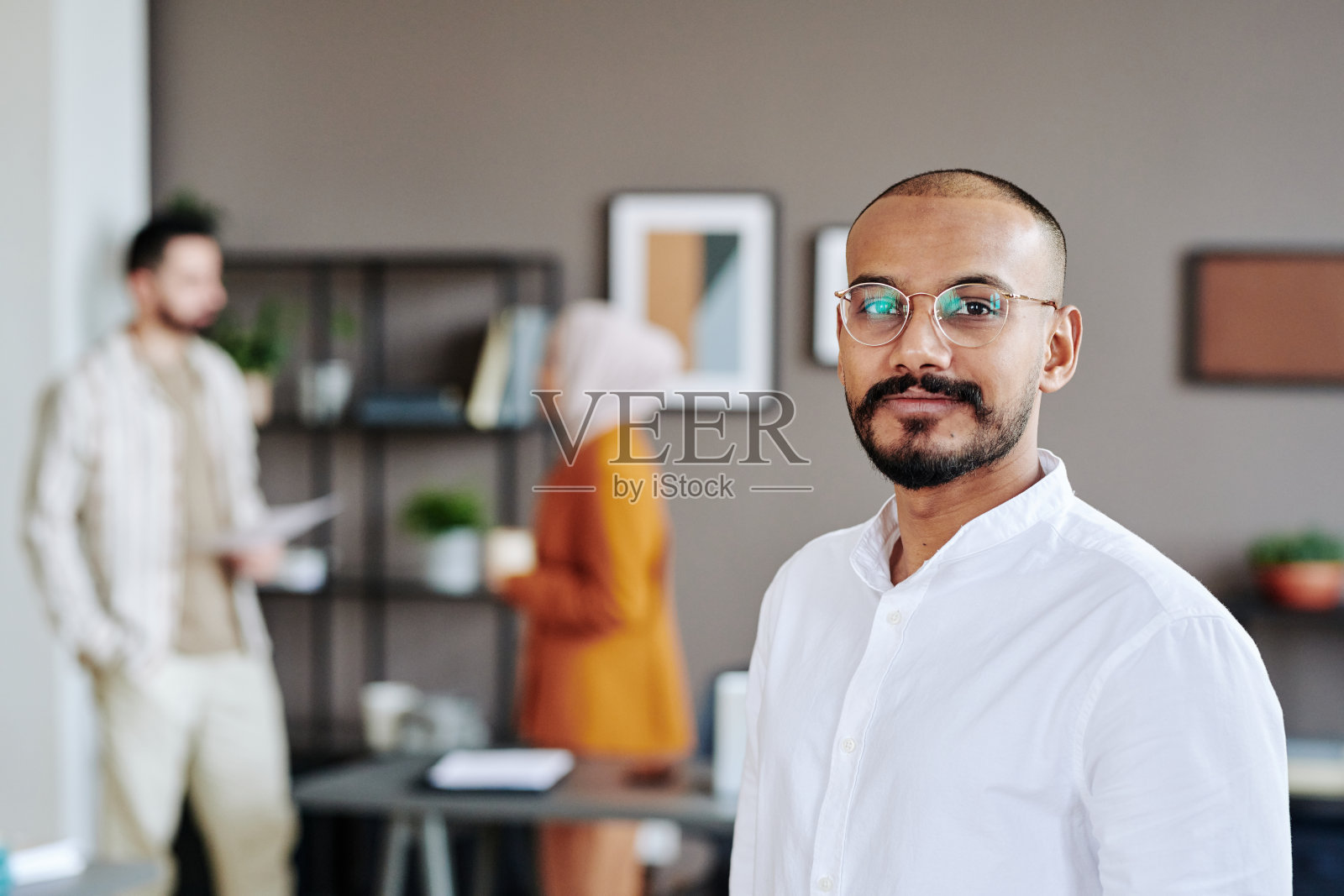 快乐的穆斯林商业团队的年轻领袖与他的同事对抗照片摄影图片