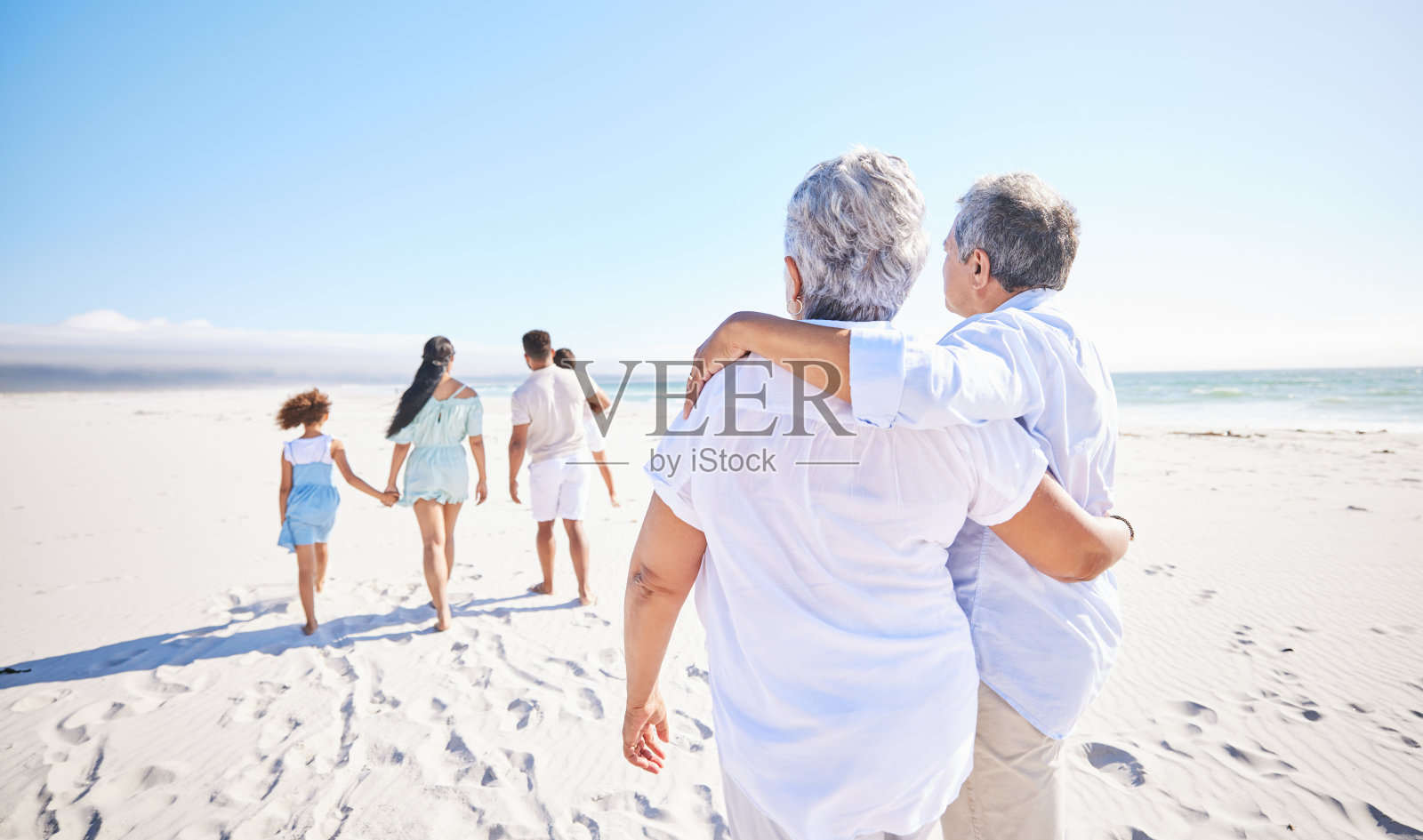 老年夫妇与家人一起享受海滩假期,祖父母同行,年轻一代享受户外活动照片摄影图片