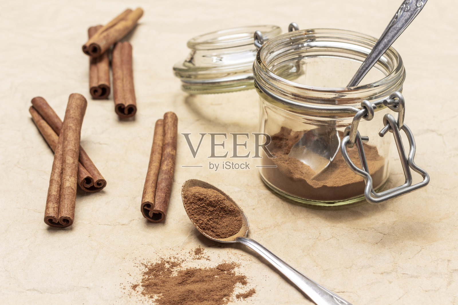 肉桂粉在勺子和玻璃罐里。照片摄影图片