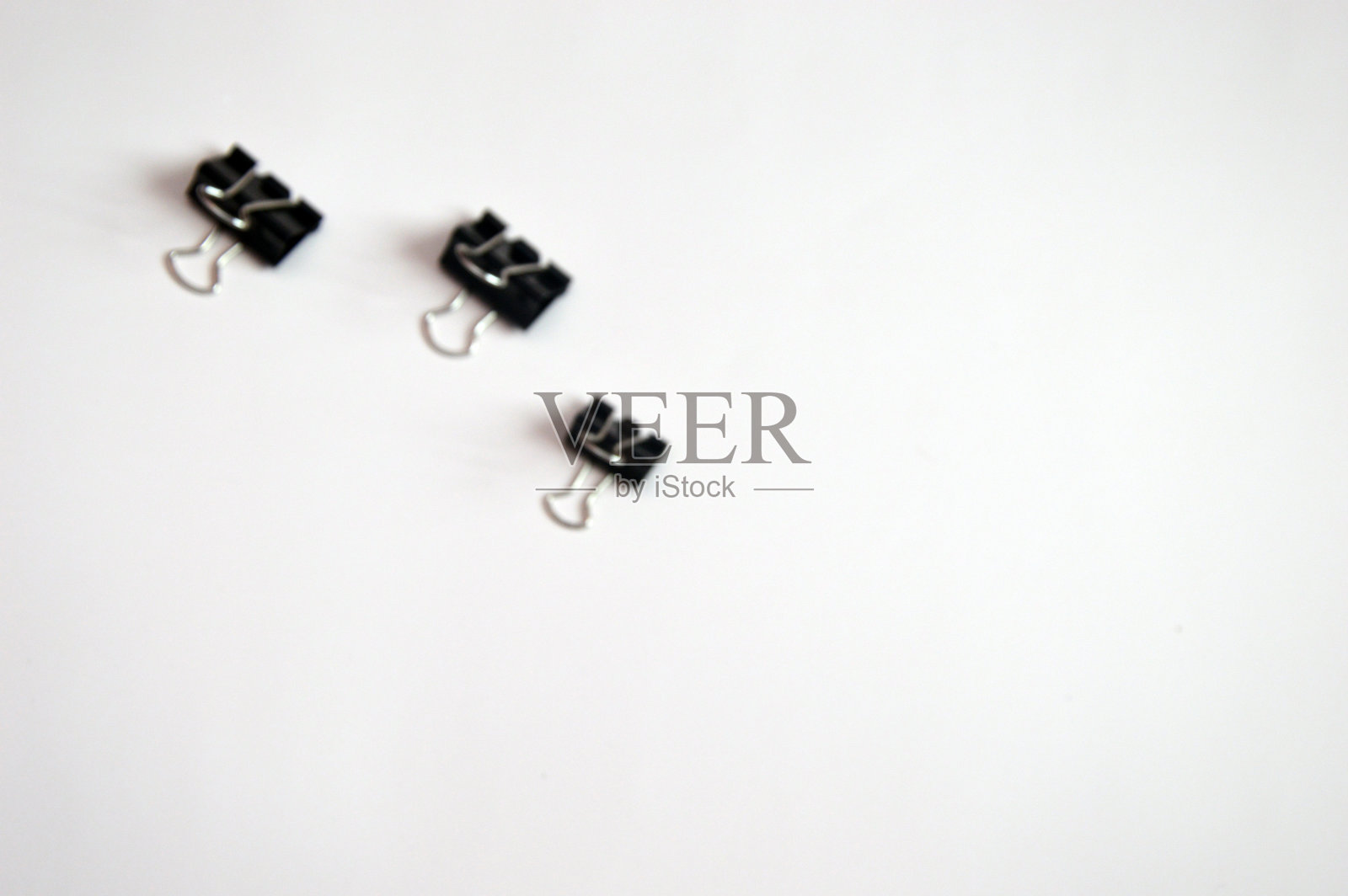 黑色回形针,文件回形针配件,文具隔离在背景上。释放文本空间。照片摄影图片