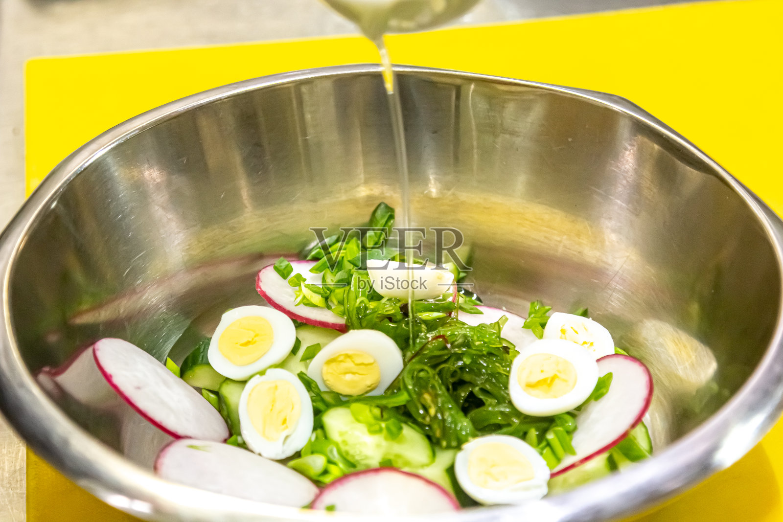 羽衣甘蓝、牛油果、萝卜、黄瓜、橄榄油沙拉和煮熟的鸡蛋——美味健康的早餐,轻背景上的零食照片摄影图片