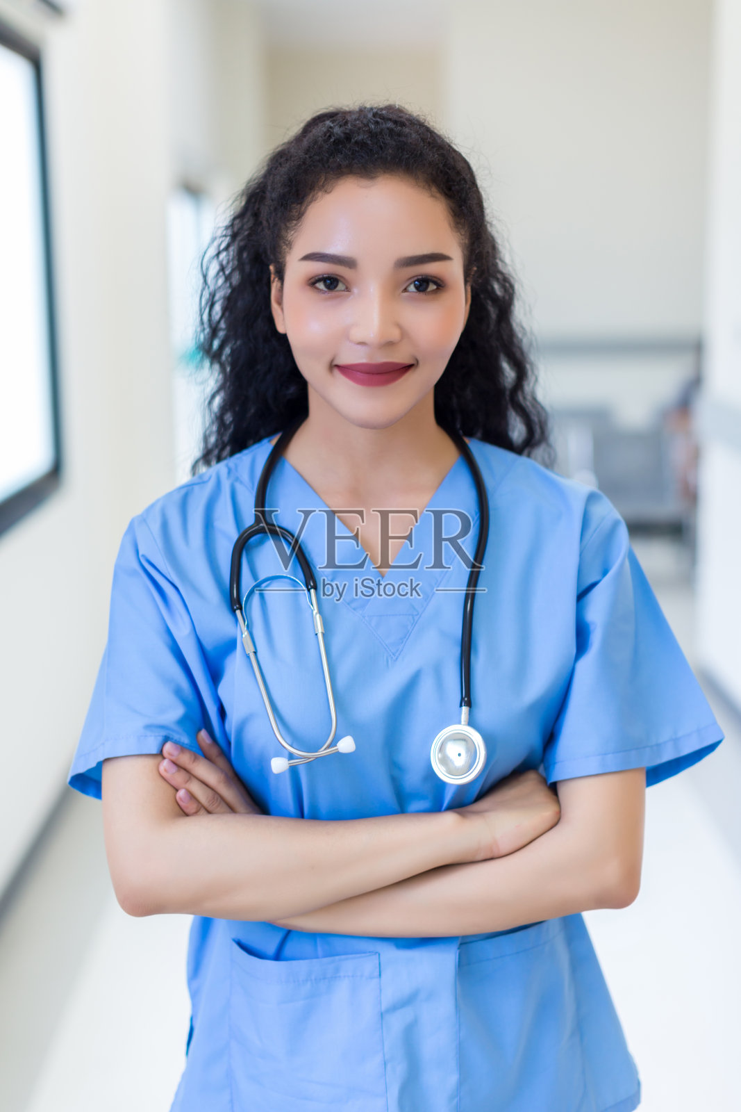 女医生站在医院。卫生保健工作者。带着听诊器的女药剂师对她在医院的工作感到满意。黑人健康专家戴着听诊器为病人提供支持照片摄影图片