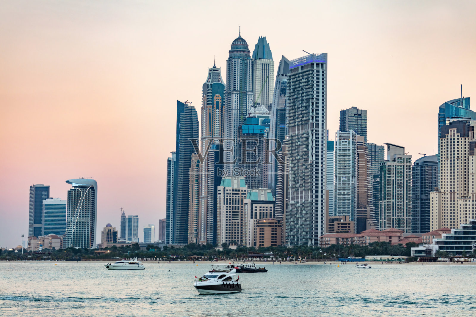 迪拜朱美拉海滩与码头摩天大楼在阿联酋日落。照片摄影图片