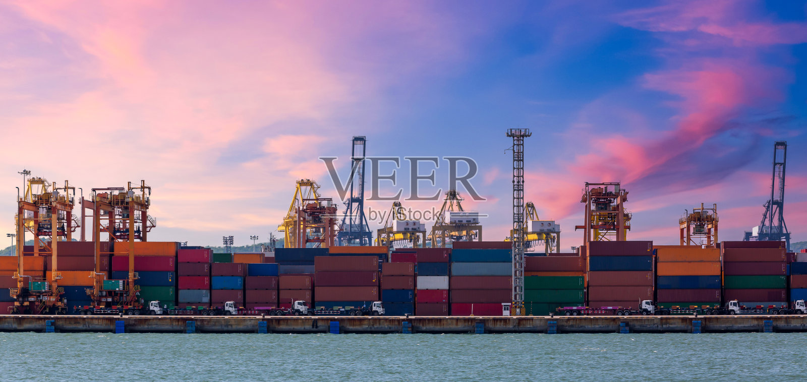 集装箱码头港口,全球业务集装箱货物货运船与工作起重机装载在深海港口和卡车运输的物流进出口集装箱运输。照片摄影图片