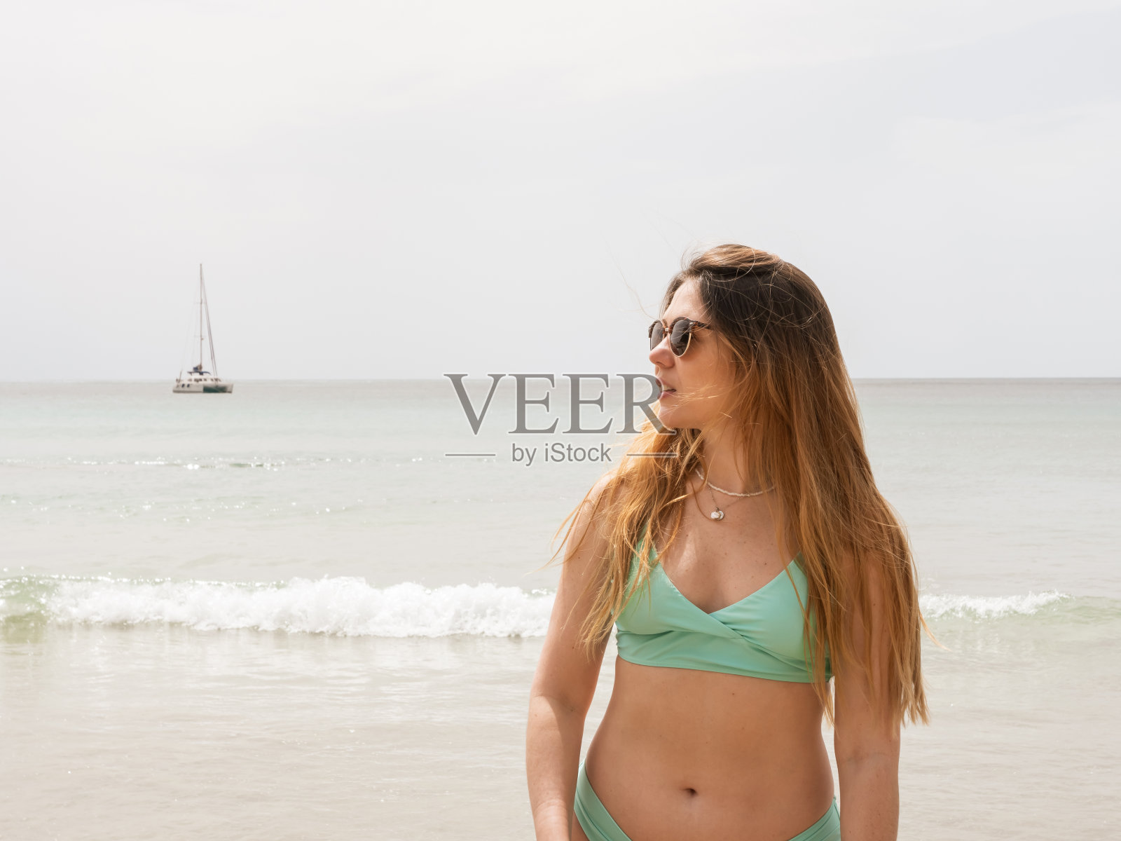 美丽的女人看到的海滩和帆船的背景照片摄影图片