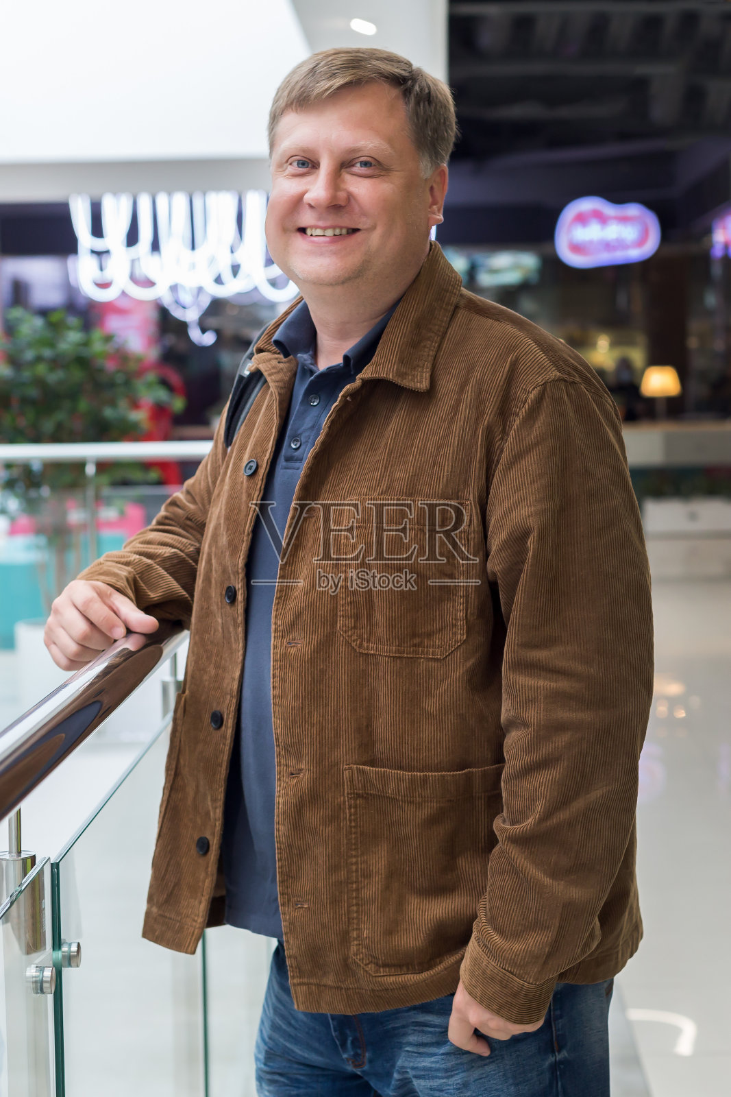 一个穿着灯芯绒夹克的快乐成年人在商场里照片摄影图片
