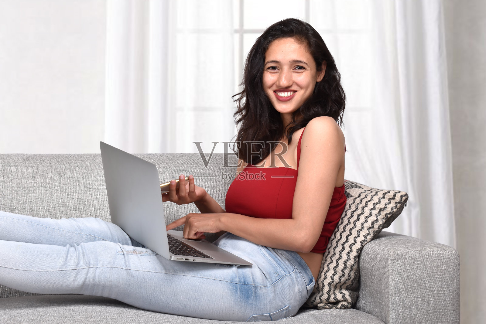 年轻女子坐在沙发上用笔记本电脑工作照片摄影图片