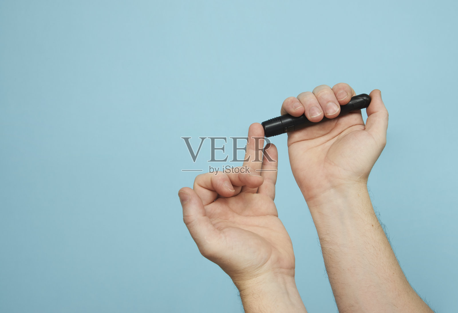 拿着柳叶刀笔做糖尿病检查的人,特写照片摄影图片