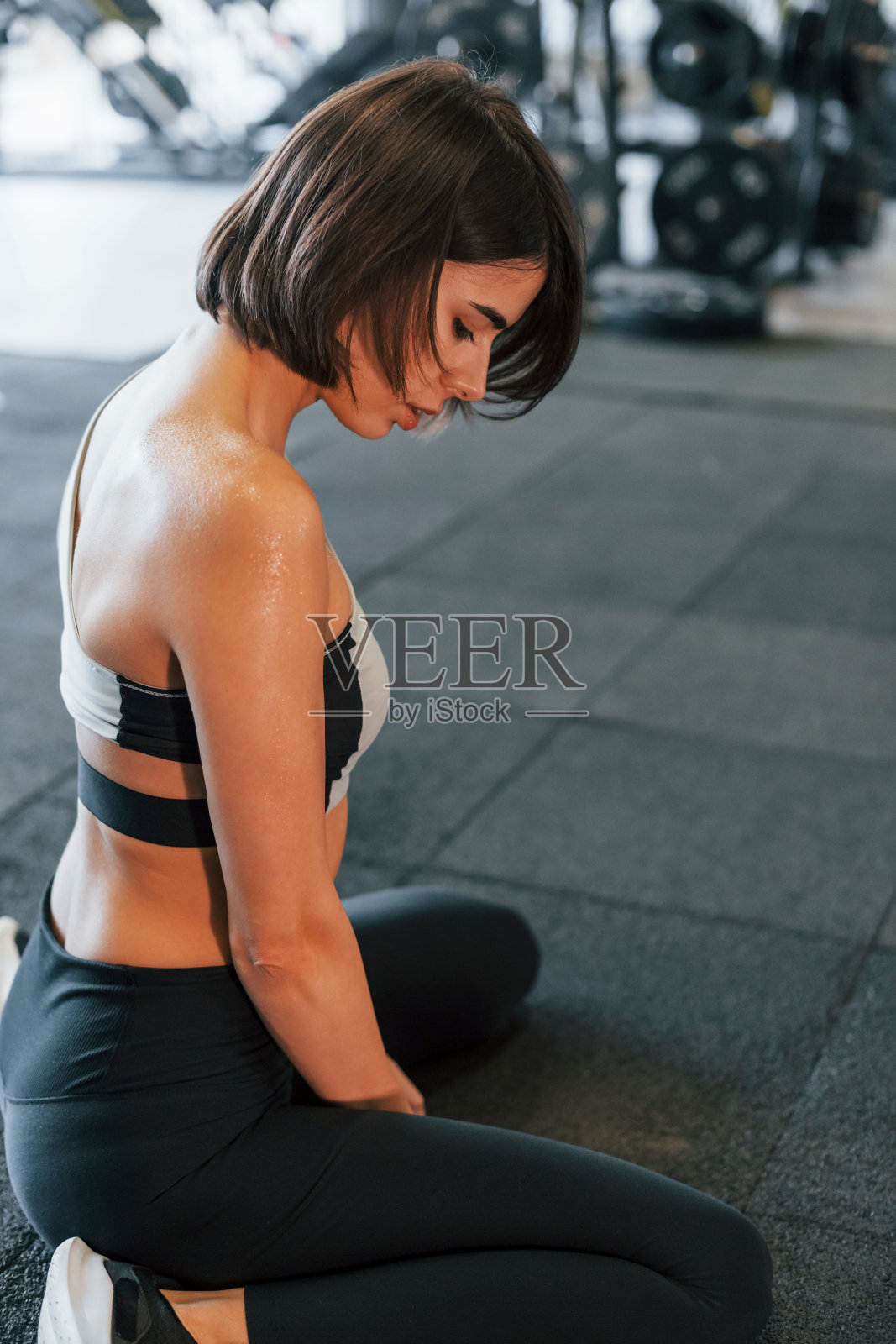 累了,休息一下。穿着运动服身材苗条的女人在健身房照片摄影图片