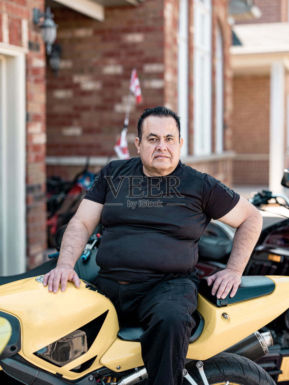 成熟的拉丁男人坐在他的摩托车上照片摄影图片