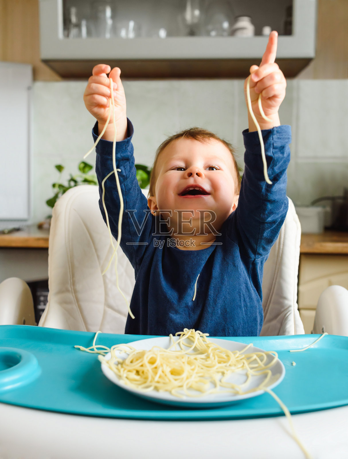 一个有趣的孩子对意大利面很满意照片摄影图片