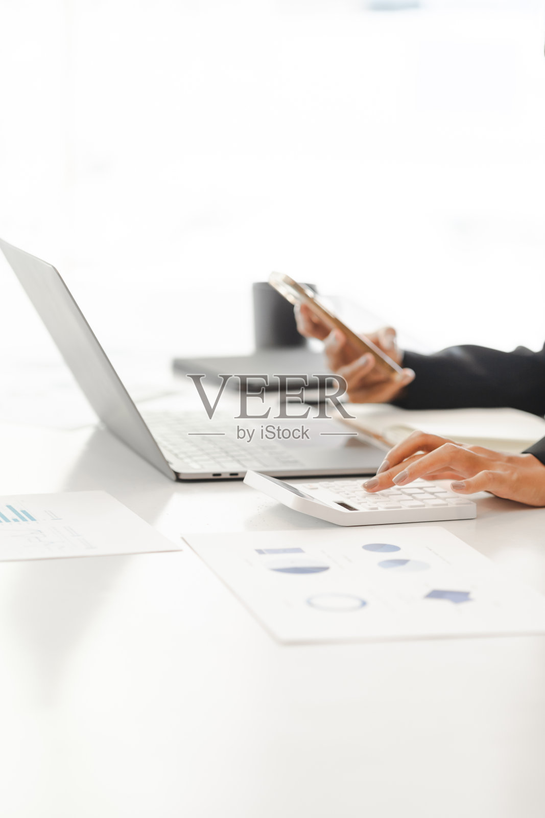 商业女性使用计算器工作与财务报告。照片摄影图片