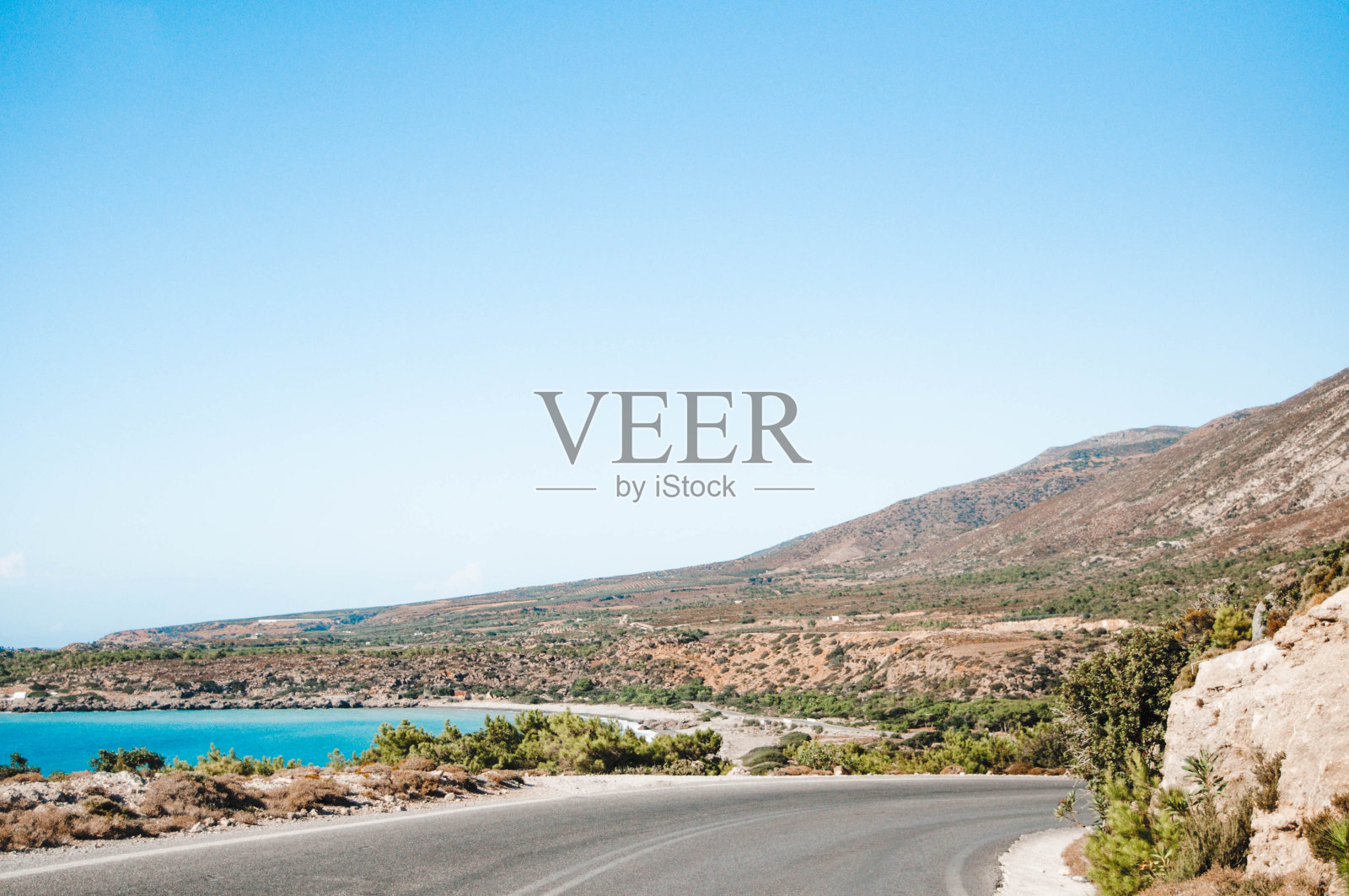 希腊克里特岛,有道路、山丘和海滨的景观。照片摄影图片