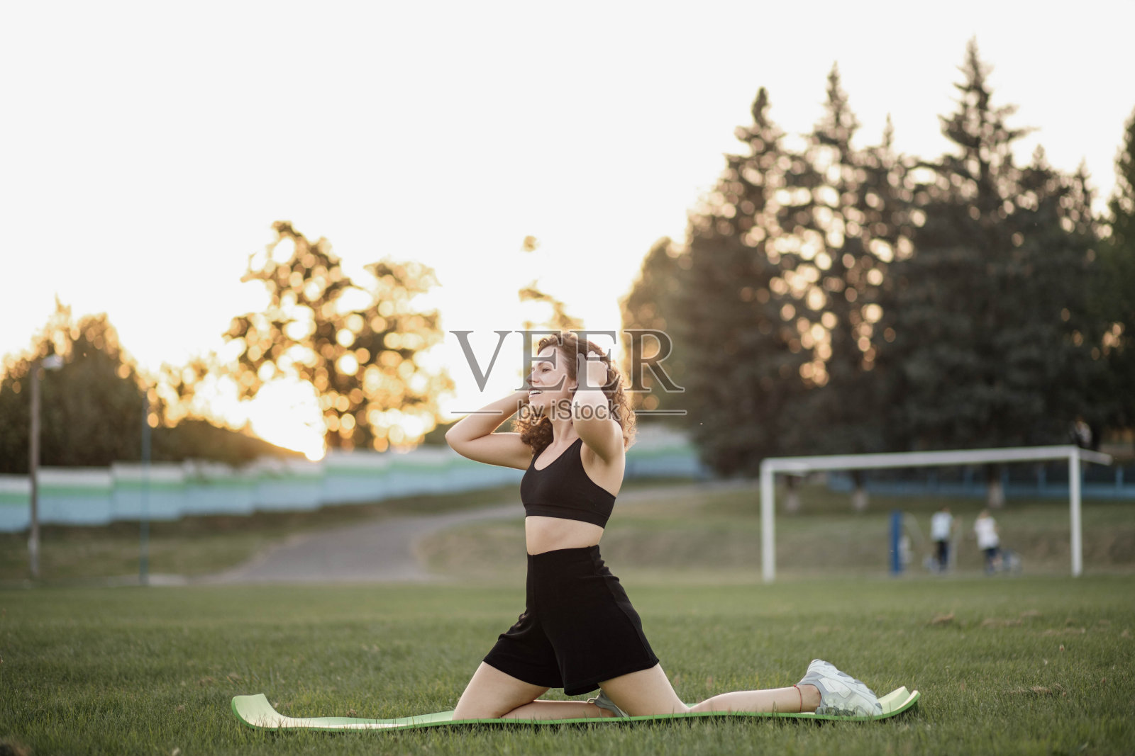 健壮的卷毛年轻女子在体育馆里进行健身训练。照片摄影图片