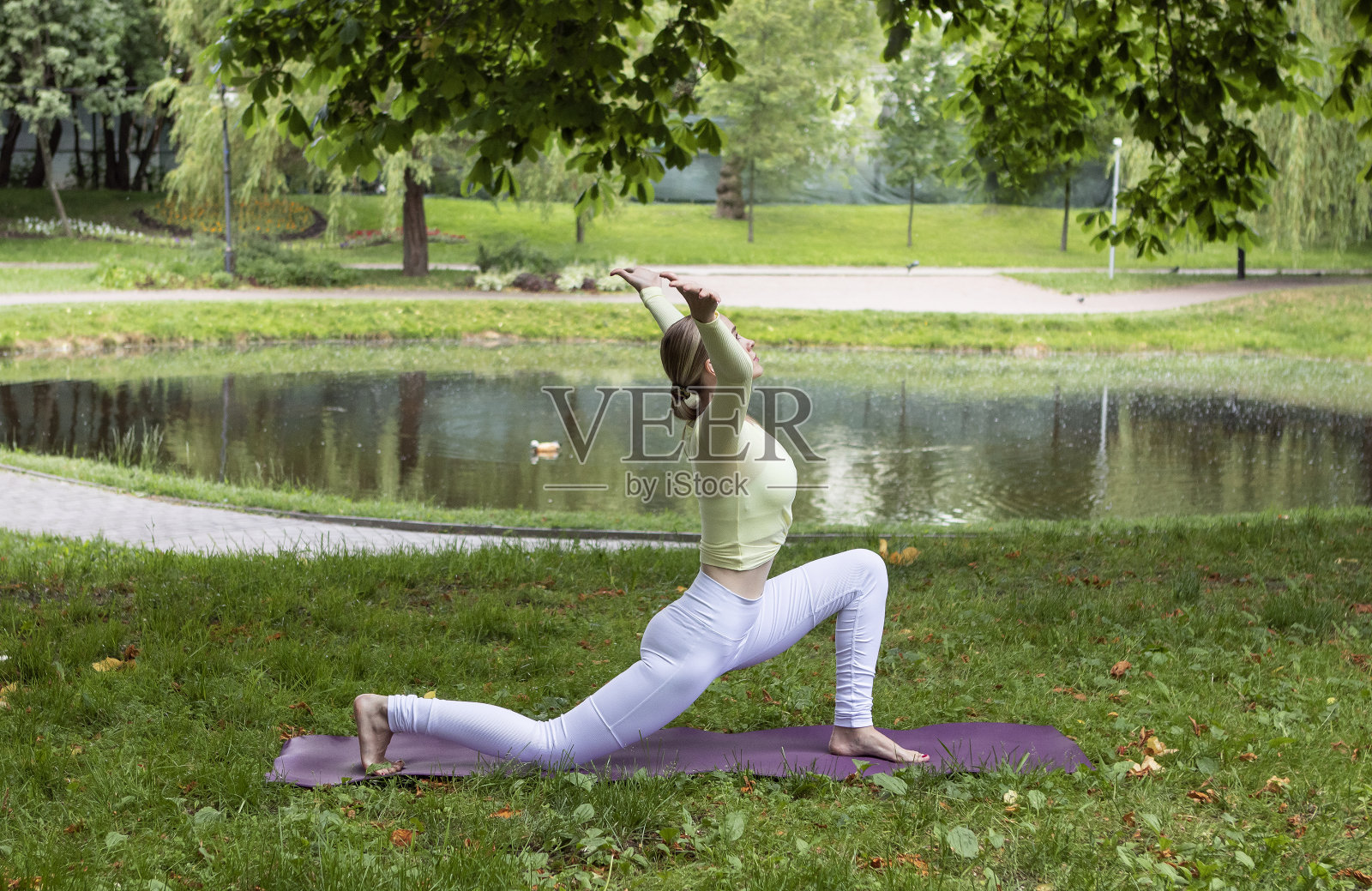 夏天,年轻的女孩在公园里做瑜伽照片摄影图片