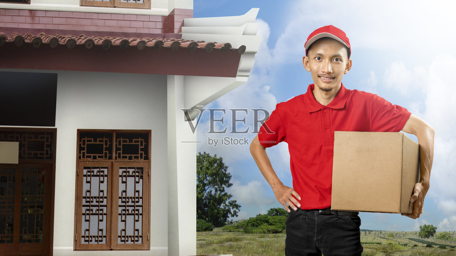 带着帽子的快递员拿着一个包裹照片摄影图片