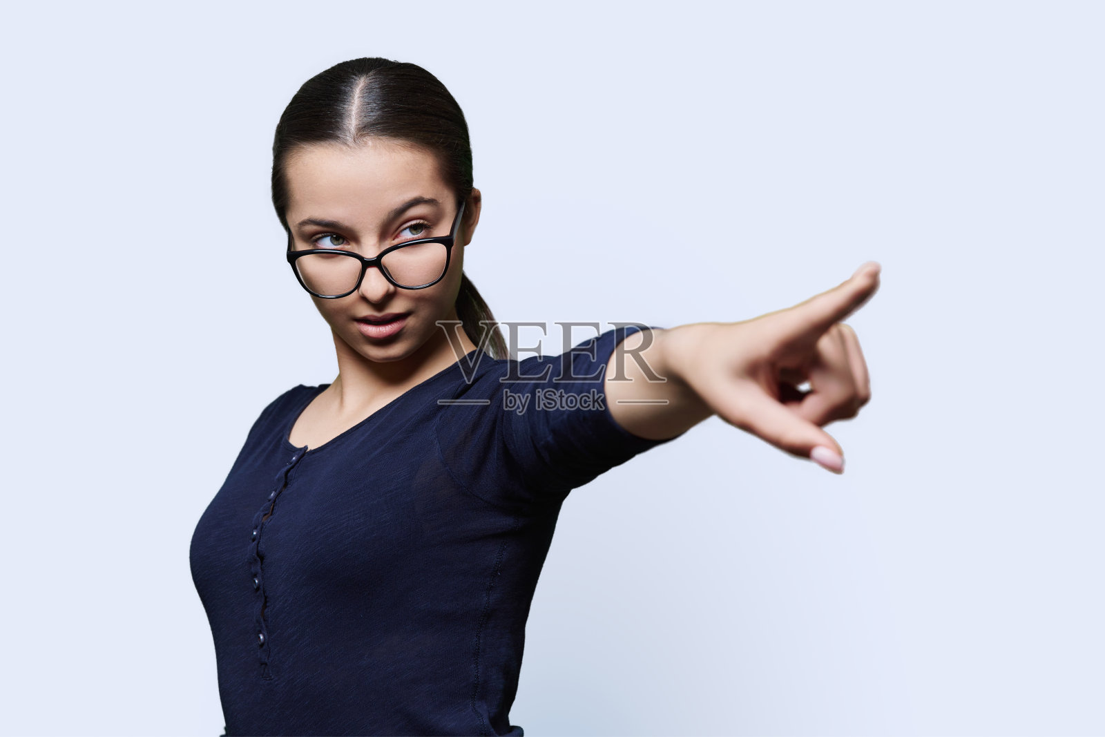 严肃的十几岁女孩学生用手指指着空白的文字照片摄影图片