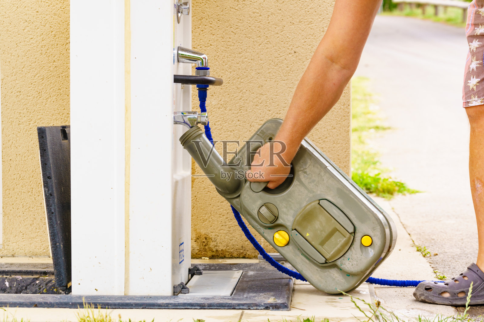 男子在倾倒站清空大篷车水箱厕所磁带。照片摄影图片