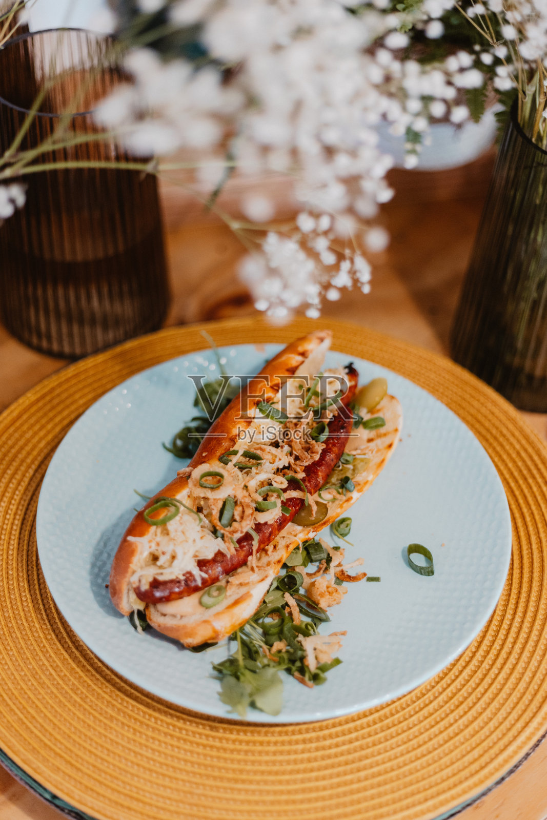 垂直特写的美味热狗在一个白色的盘子。照片摄影图片