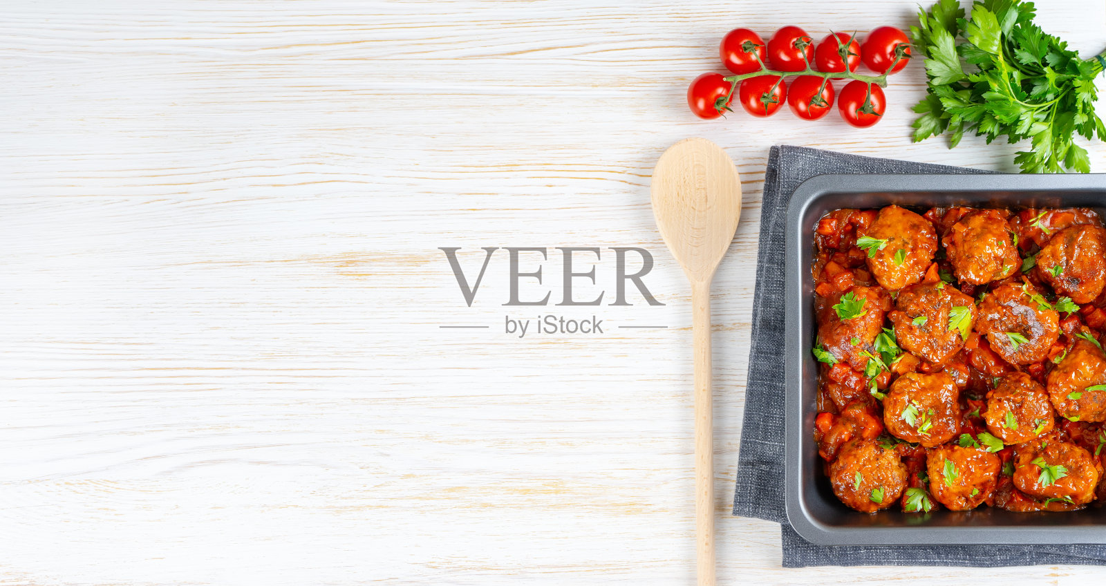 自制肉丸配番茄酱和香料,用黑色平底锅,白色木制背景照片摄影图片