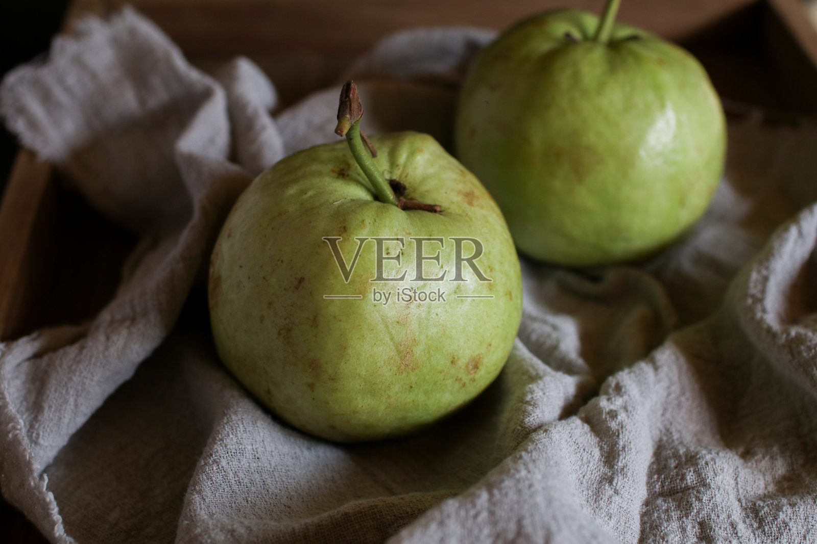 番石榴与叶白色木制深色背景。新鲜有机热带水果,维生素C含量高,健康饮食。照片摄影图片