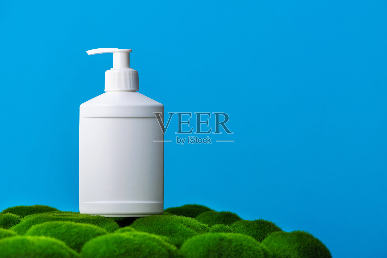 绿色草地上的白色洗发水饮料瓶照片摄影图片